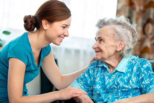 Support worker giving reassurance to an older person and family member at home